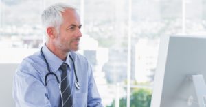 male doctor using desktop computer